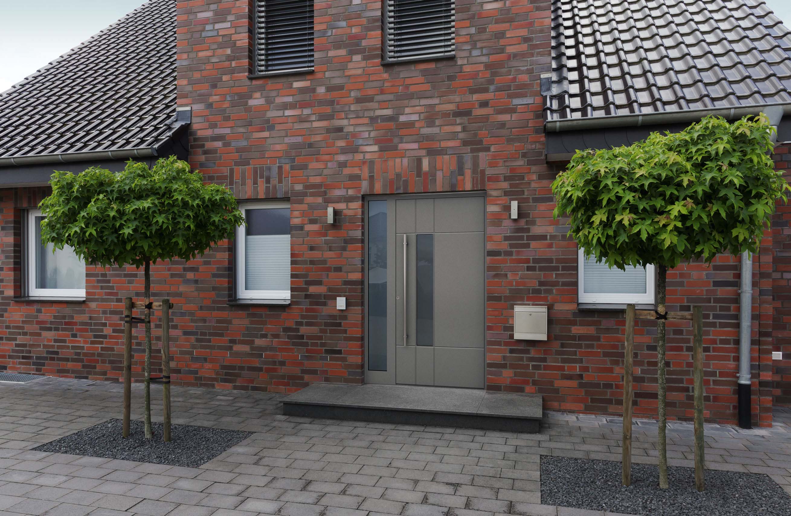 Moderne Haustür mit satiniertem Glas in Klinkerfassade